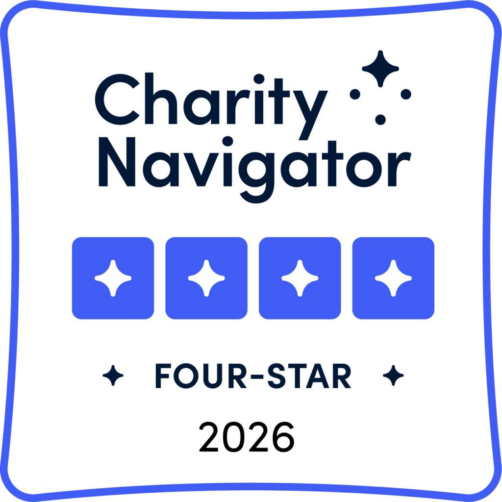 A digital badge from Charity Navigator showing a four-star rating for Teach Access for 2026. The badge features the text “Charity Navigator” at the top, four blue star icons in the center, and “FOUR-STAR 2026” below.