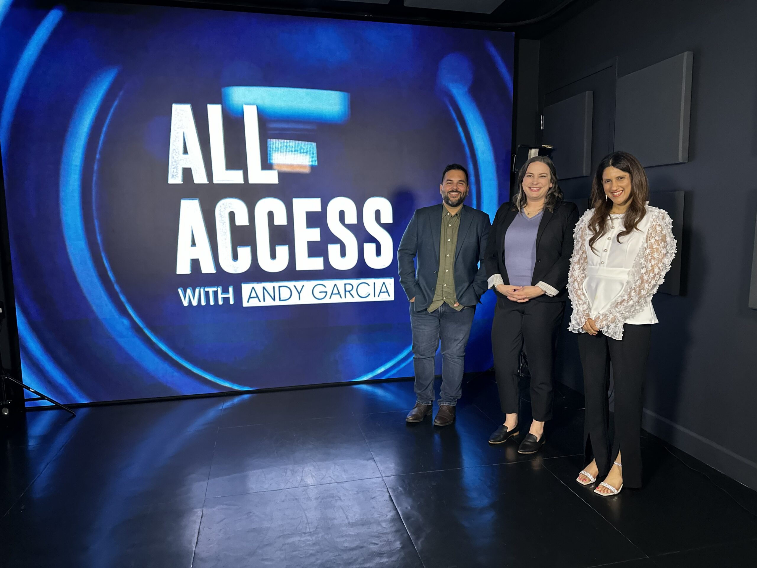 Kate Sonka, Rolando Mendez, and Meena Das standing in fronf of the All Access with Andy Garcia backdrop
