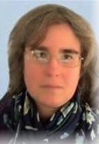 A portrait of Irina Knokh, a woman with light brown hair, wearing rectangular rimless glasses and a dark blue scarf with white floral patterns. The background is a soft, light blue.